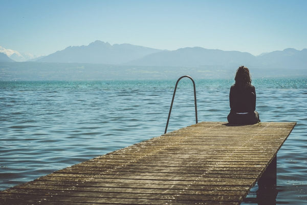 woman sitting on end of jetty