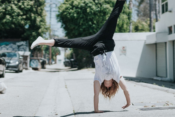 woman doing cartwheel in street