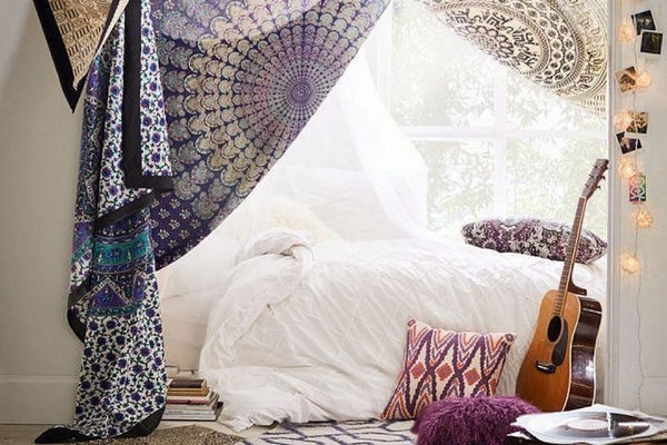 hippy curtains hanging over a bed and a guitar