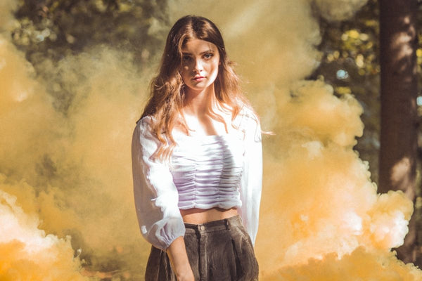 woman with yellow smoke behind her